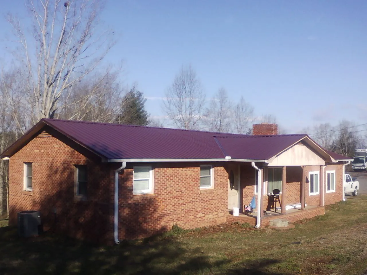 Burgundy metal roof on a brick ranch home with a new addition in Lugoff