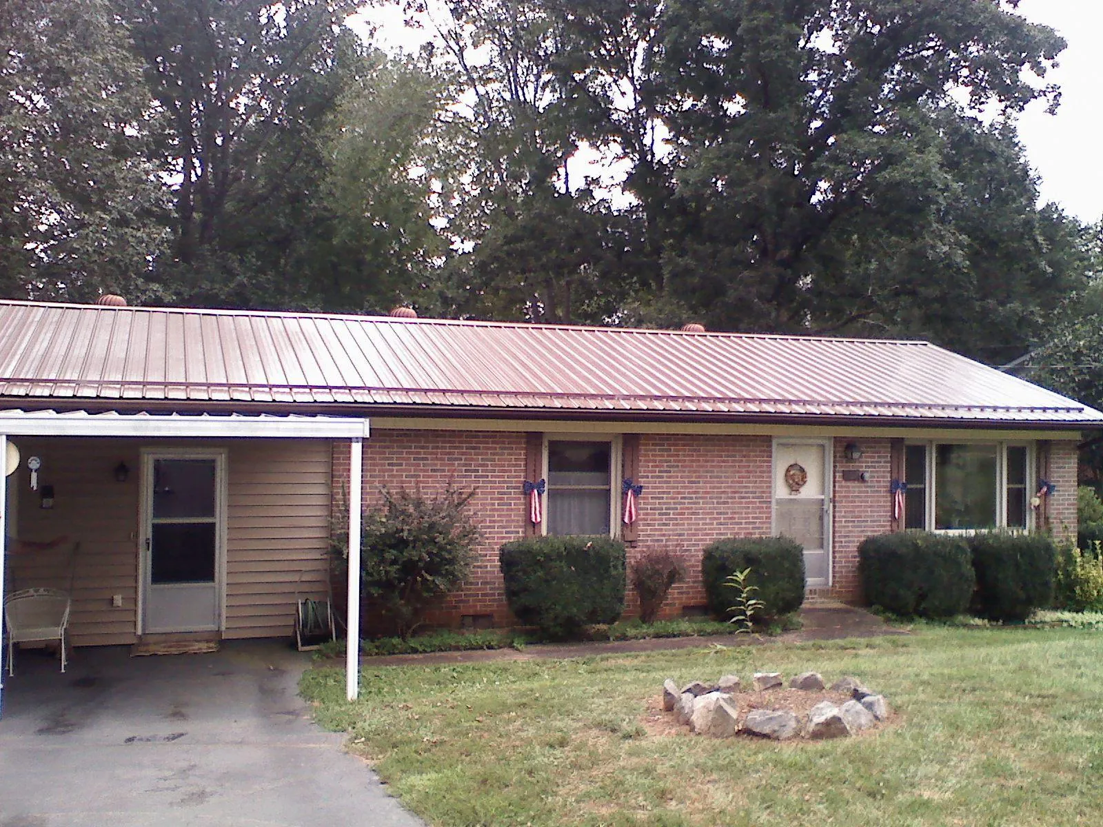 Bronze metal roof and carport on a brick ranch home — Roof Repair work by our crew in Lugoff
